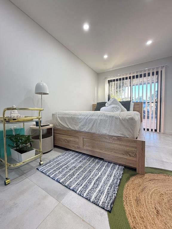 a bedroom with a large bed and a rug at Fully equipped brand new built studio in Chipping Norton