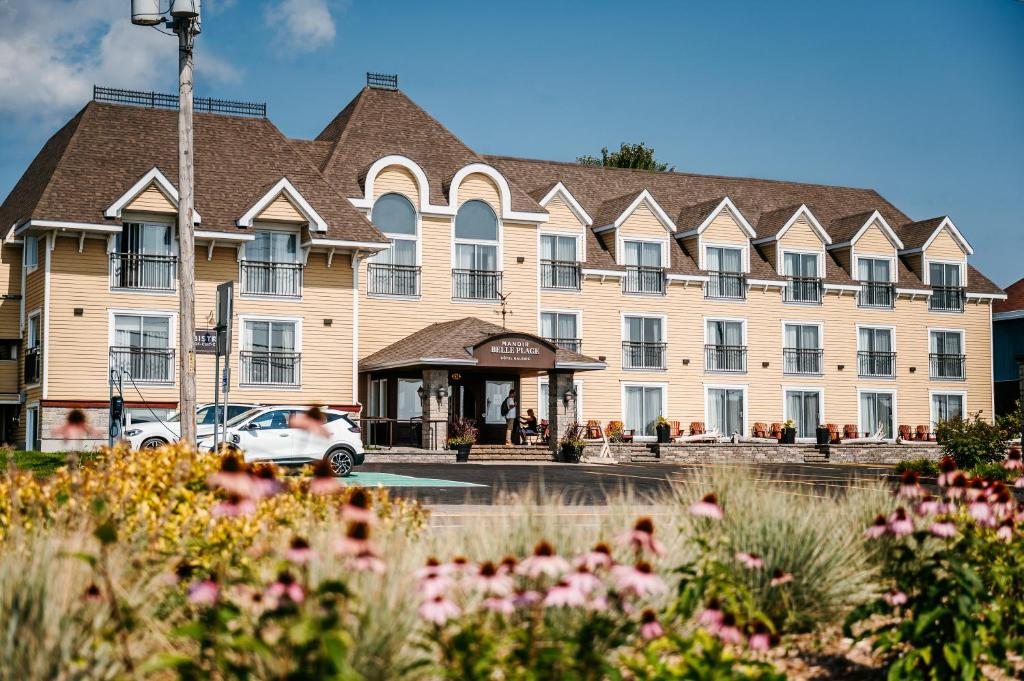 a large building with a car parked in front of it at Manoir Belle Plage in Carleton sur Mer