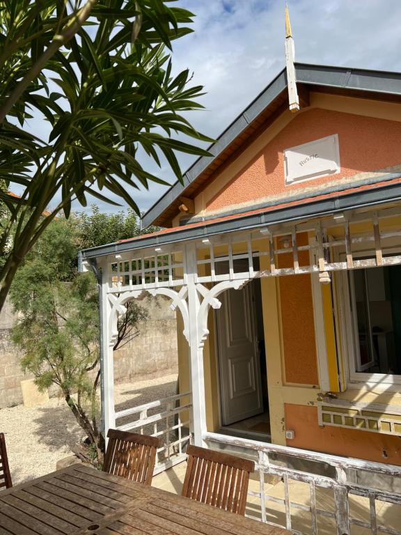 a porch of a house with a table and chairs at Cottage 50m de la plage in Châtelaillon-Plage