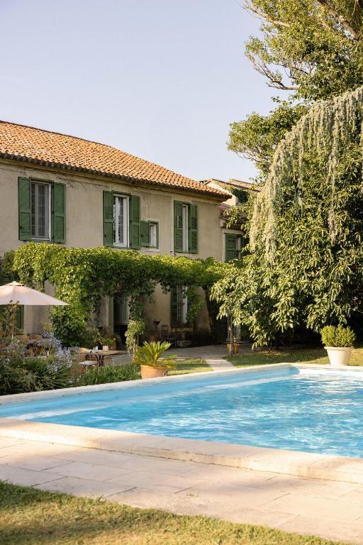 a house with a swimming pool in front of a house at Hotel Moulin d'Aure in Saint-Rémy-de-Provence