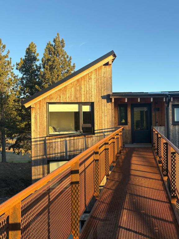 a wooden walkway leading to the front of a building at Hoyo 5 Aldea de golf in San Martín de los Andes