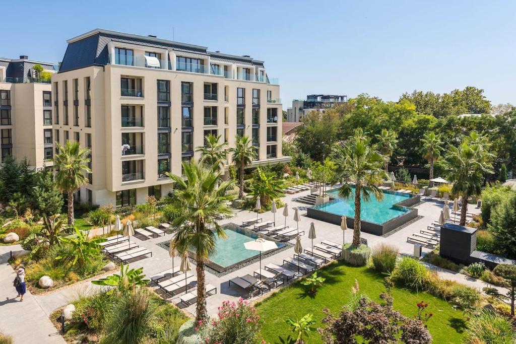 an aerial view of a hotel with two pools and palm trees at Artistic space in Azur Premium in Varna City