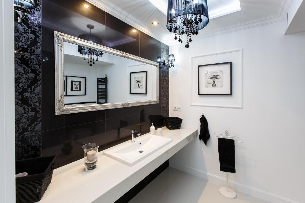La salle de bains est pourvue d'un lavabo et d'un miroir. dans l'établissement Apartamenty Sienkiewicza - bezpłatny parking, centrum, park, fv, à Kielce