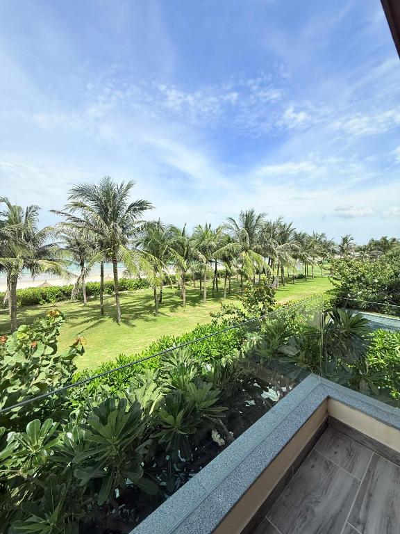 a view from the balcony of a resort with palm trees at Villa 3BR Beach Front in Cam Lâm