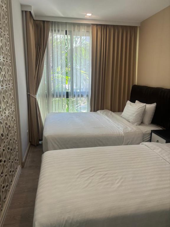 una camera d'albergo con due letti e una finestra di Modern studio Royal lee the terminal phuket airport a Ban Bo Han