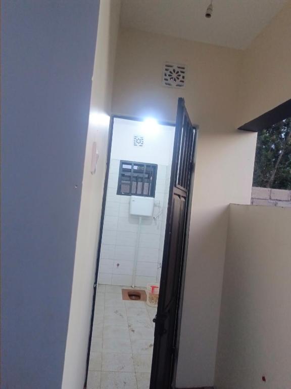 an open door to a bathroom with a window at Old Moshi Park in Arusha