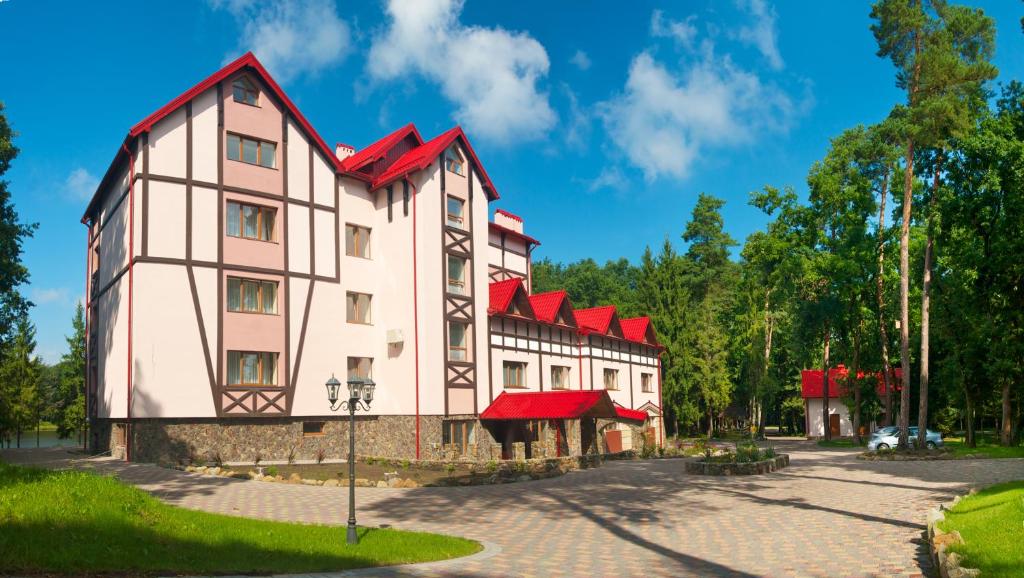 ein großes Gebäude mit roten Dächern auf einer Straße in der Unterkunft Sherwood Hotel in Dovgomostys”ka