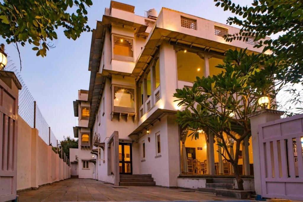 a large white house with a tree in front of it at Villa Sagat Raaso in Udaipur