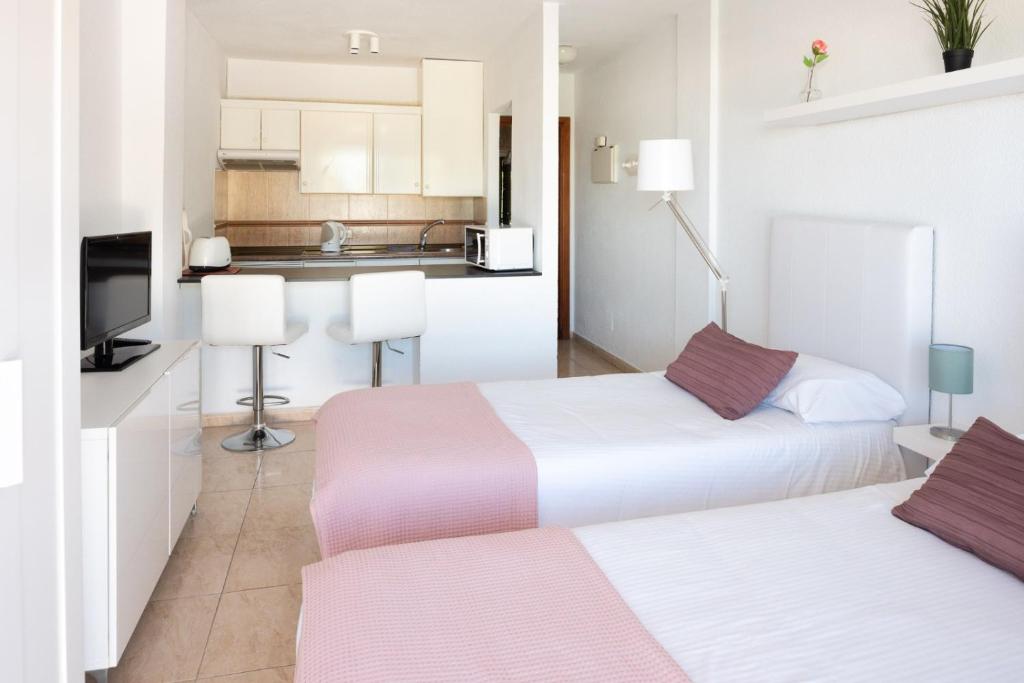 Costa de AdejeにあるModerno estudio con Terraza y Piscina en Costa Adejeのキッチン付きの小さな部屋にベッドが2つあります