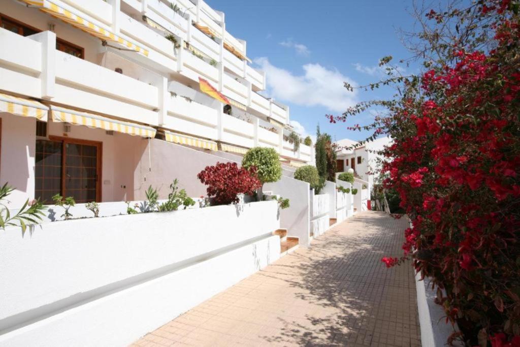 a white building with flowers on a street at Moderno estudio con Terraza y Piscina en Costa Adeje in Costa de Adeje