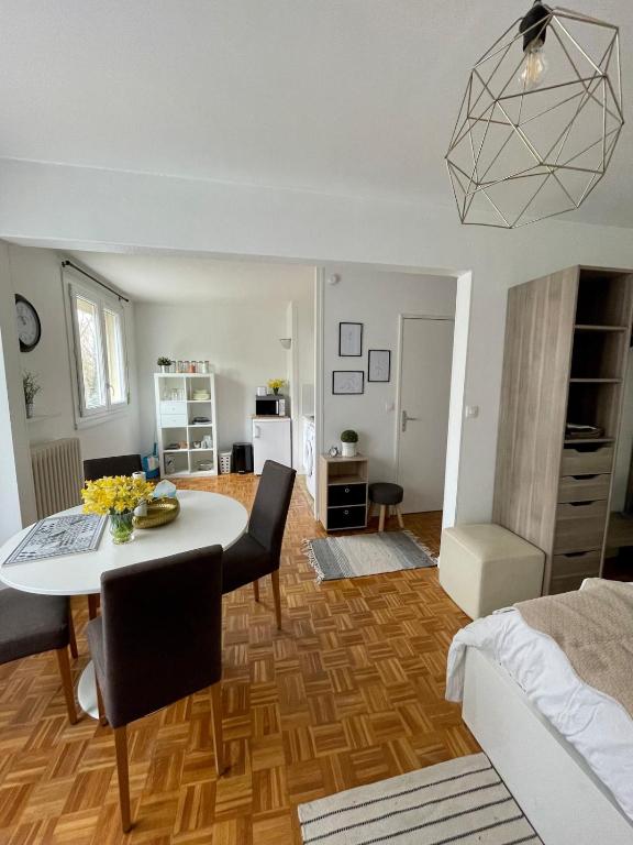 a living room with a table and a dining room at Le Studio Lumineux in Compiègne