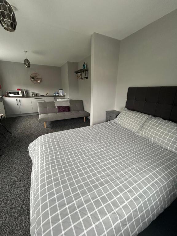 a white bedroom with a bed and a couch at Happy Airfield Studio in Sandtoft