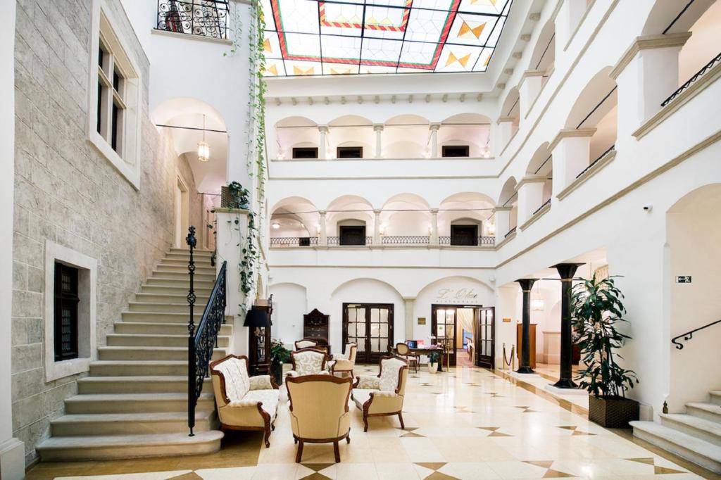 Blick auf die Lobby eines Gebäudes mit Stühlen und Treppen in der Unterkunft Arcadia Boutique Hotel in Bratislava