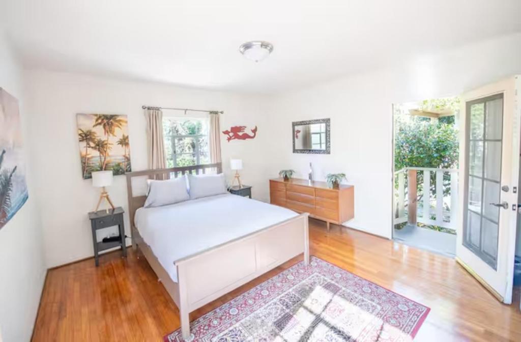 a white bedroom with a bed and a rug at The Marlowe Seaside Villa in Santa Barbara