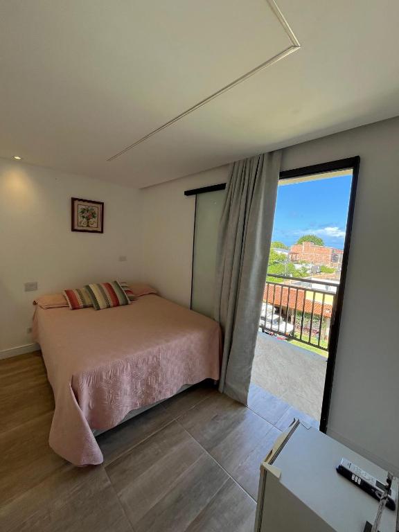 a bedroom with a bed and a large window at Suite Sol Maragogi in São José da Coroa Grande