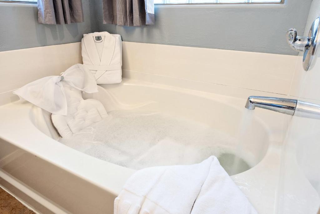La salle de bains est pourvue d'une baignoire blanche et de serviettes. dans l'établissement Chill & Thrill | Pool, Hot Tub • Family Game Villa, à Casa Grande