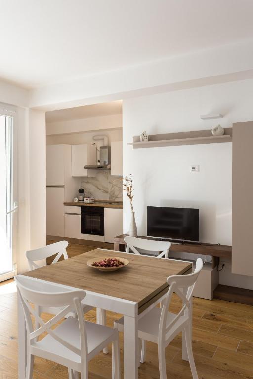 eine Küche und ein Esszimmer mit Tisch und Stühlen in der Unterkunft Dimora Caprera - Appartamenti in Falconara Marittima