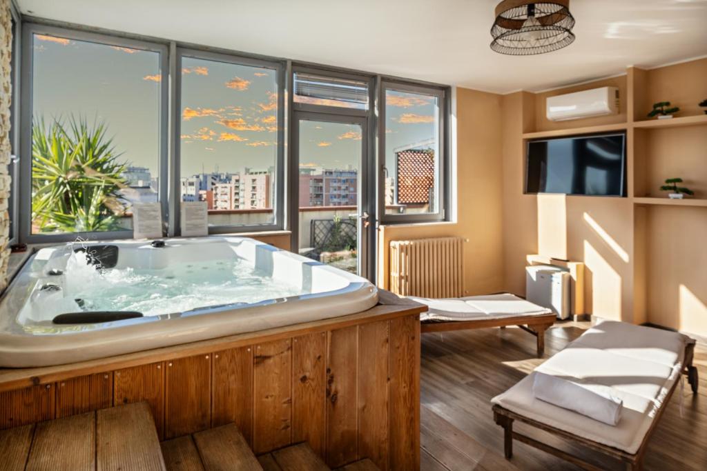a large bath tub in a room with windows at Penthouse Station luxury apts Le dimore in Brindisi