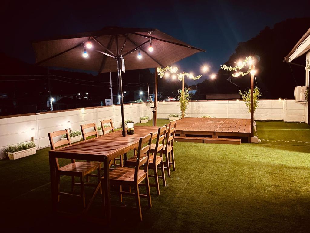 a wooden table with chairs and an umbrella on a patio at KeiCo in Narusawa