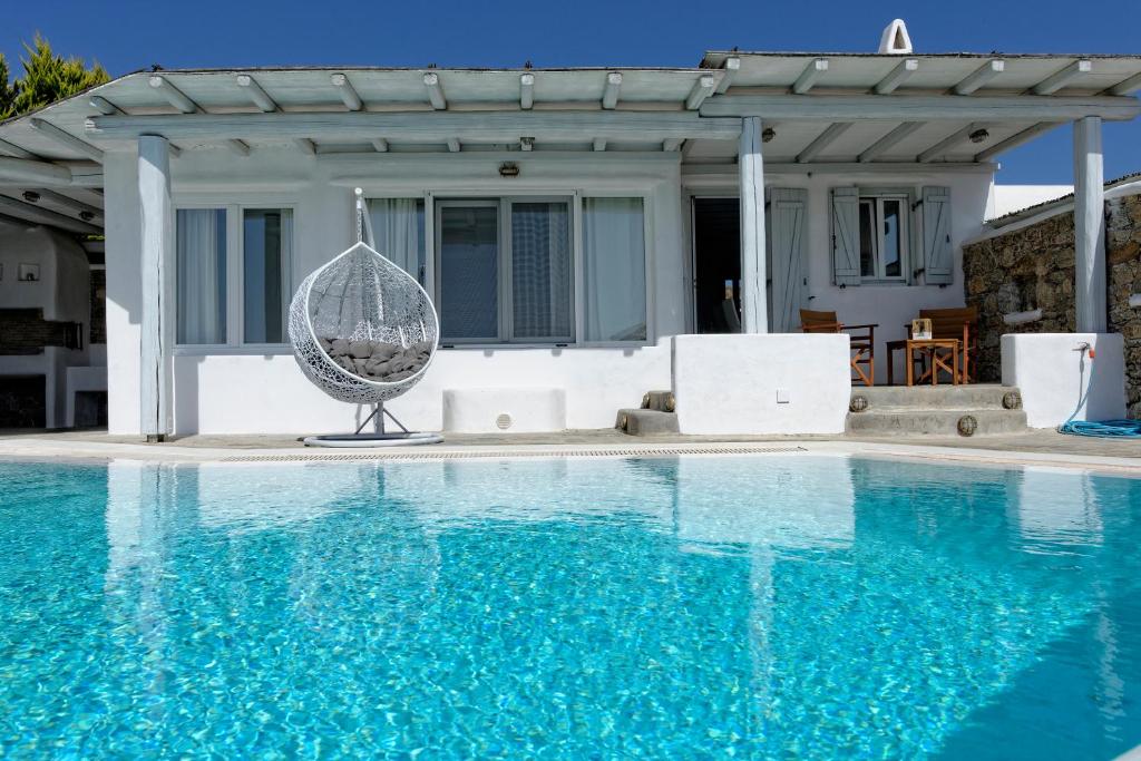 a swimming pool with a swing and a house at Villa Harmony in Kalafatis