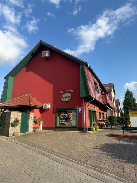 a red and green building on a street at Apartament Nowa in Bolesławiec