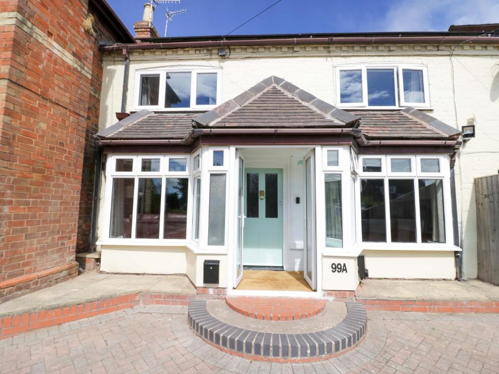 Weißes Haus mit blauer Tür und Fenstern in der Unterkunft Cosy Cottage in Harvington in Harvington