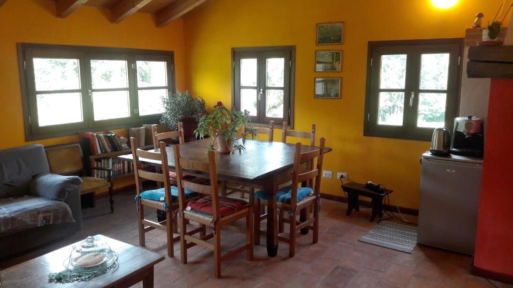 ein Esszimmer mit einem Tisch und Stühlen sowie gelben Wänden in der Unterkunft l'Oca Mannara in Ameno