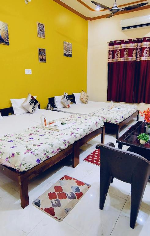 a room with two beds and a table at ATULYAM STAYs PREMIUM in Ayodhya