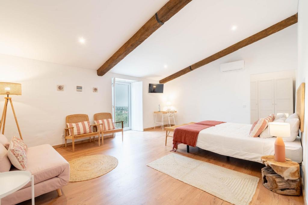 a bedroom with a bed and a living room at Casa da Nora in Fortios