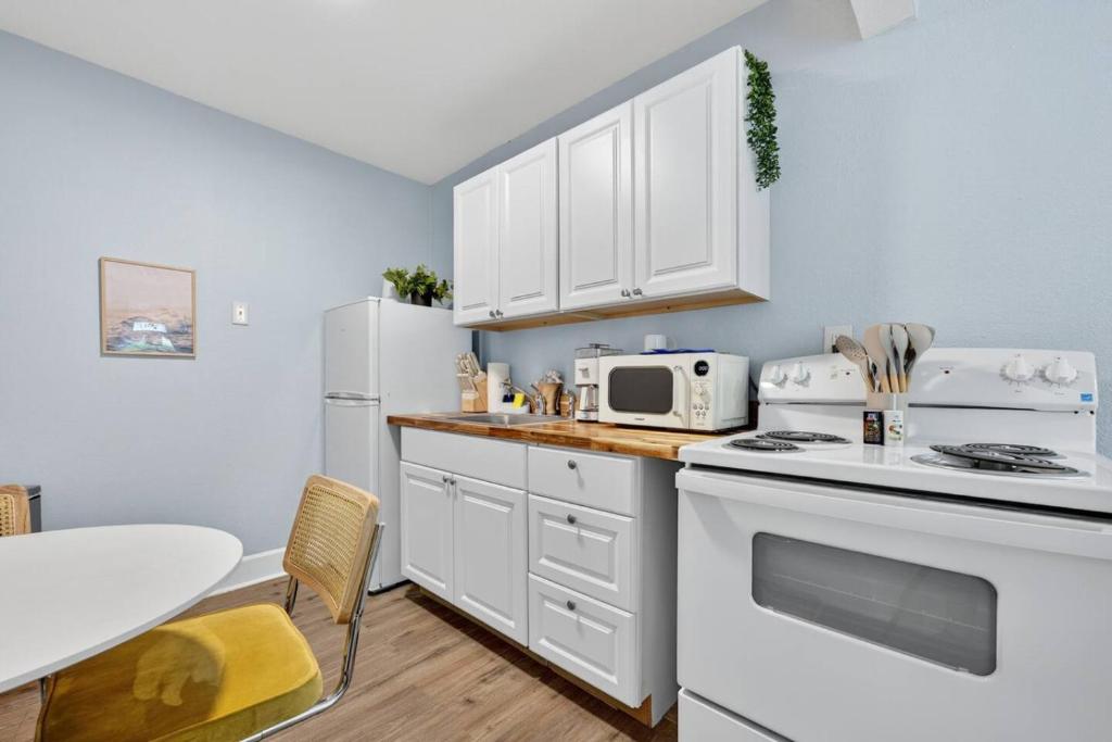 a kitchen with white cabinets and a white stove top oven at Unit 19 Tiny Haven Unwind in Pensacola in Pensacola