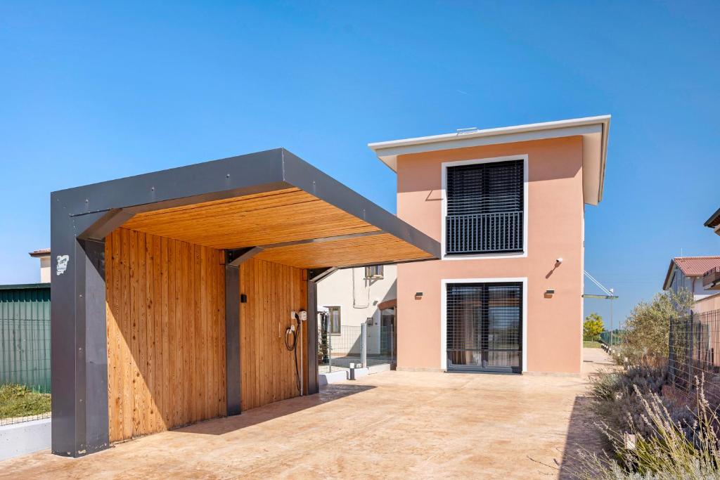 a house with a wooden door with a black roof at Villetta Independente La Perla in Ceggia