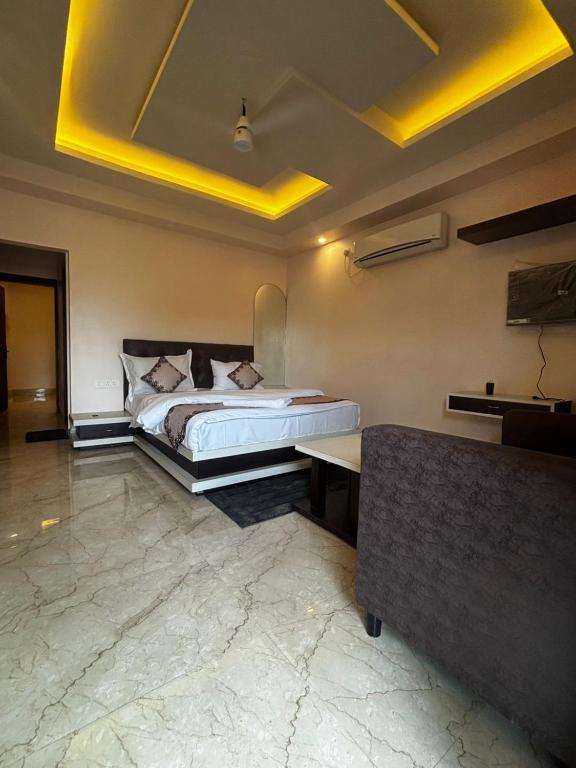 a bedroom with a bed and a couch in a room at GOLDEN VISTA RESORT - 10 Minute From Mayapur Temple in Krishnanagar