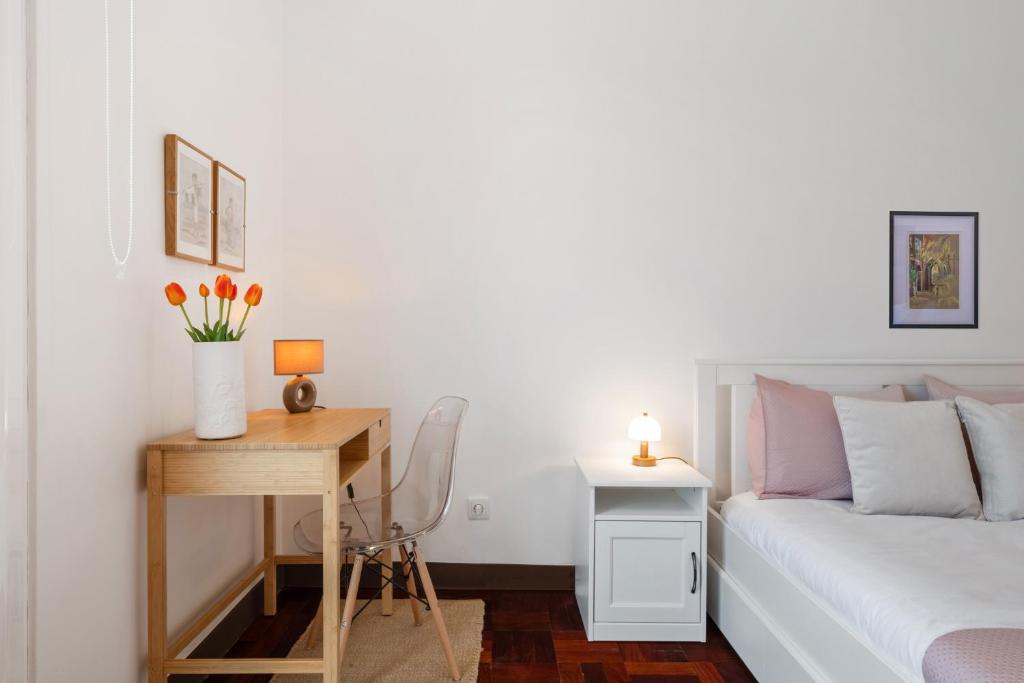 a bedroom with a bed and a table with a desk at Rumo by KAAMAH in Ribeira Brava