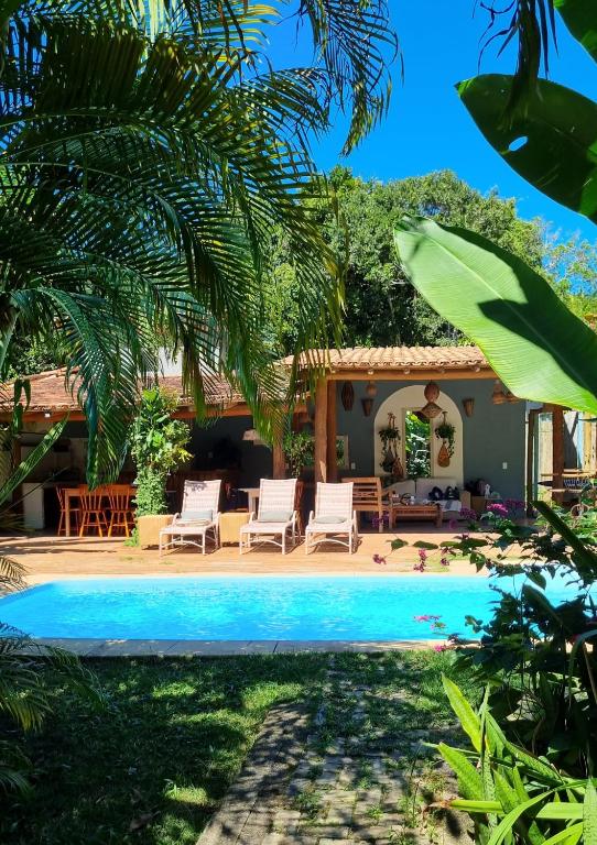 a villa with a swimming pool and a house at Vila Pitanga Trancoso in Trancoso