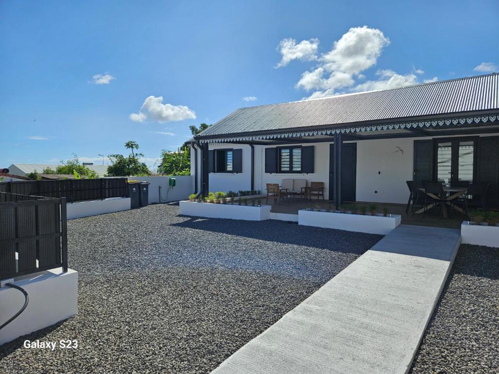 a house with a roof on a gravel yard at Ti KAZ SAMY & ANY in Sainte-Suzanne