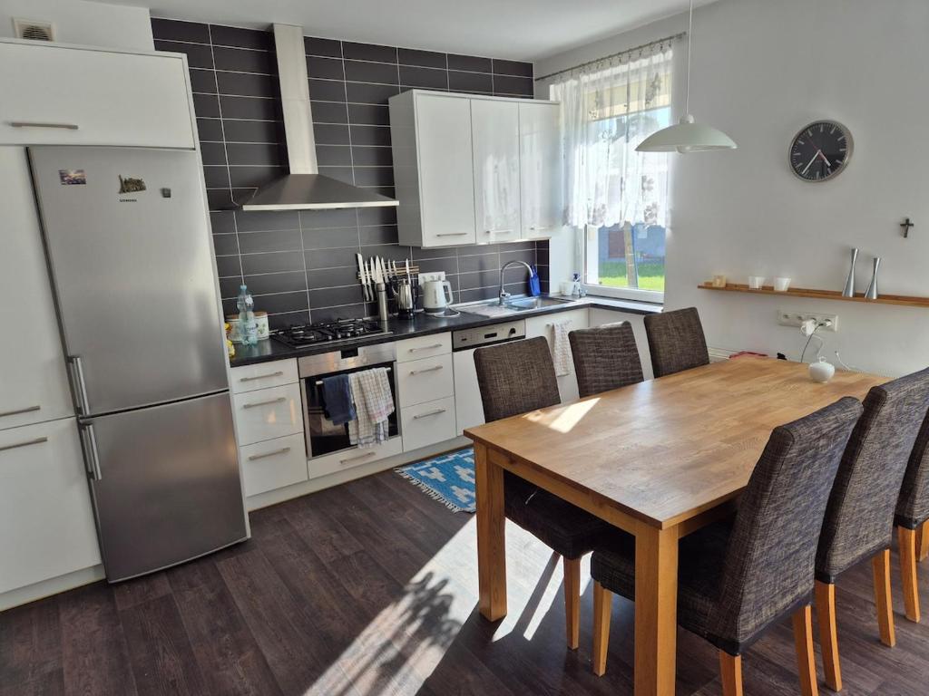 a kitchen with a wooden table and a refrigerator at Apartment in Kietrz