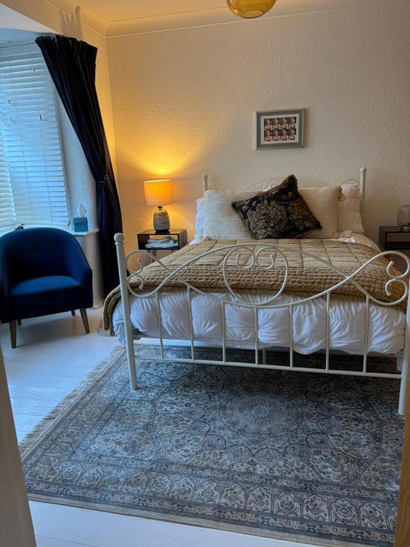 a bedroom with a bed and a blue chair at Number 78 Guest house M56 junction 12 located 5 minutes drive from Frodsham Continental breakfast Included in Frodsham