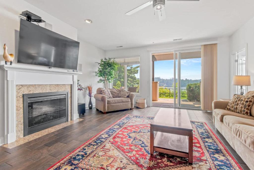 a living room with a fireplace and a flat screen tv at Luxury Lakefront Condo in Wisconsin Dells in Lake Delton