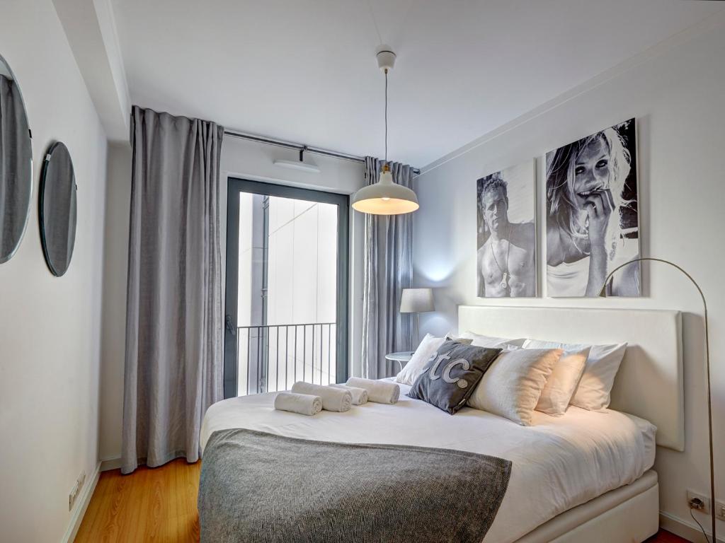 um quarto com uma cama grande e uma janela em Sonel Investe Martim Moniz Apartment by Get Your Stay em Lisboa