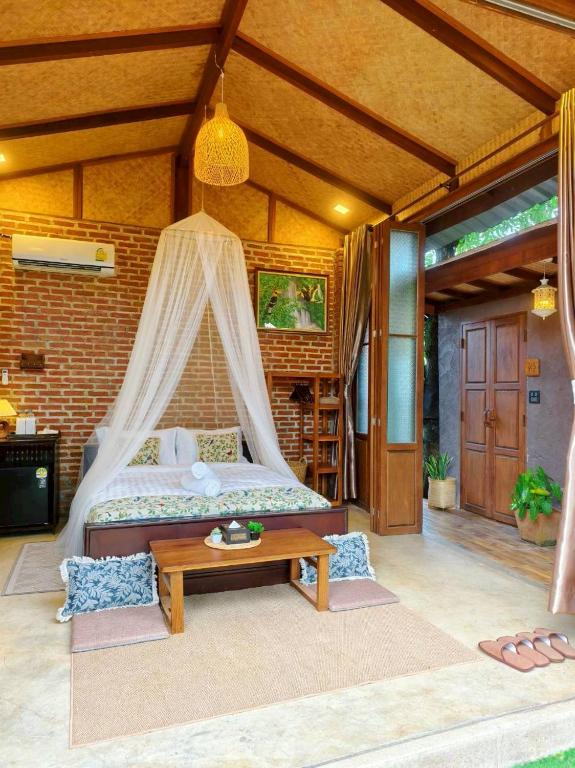 a bedroom with a bed with a mosquito net at เติมชีวา Barcafe & Guesthouse in Chiang Rai
