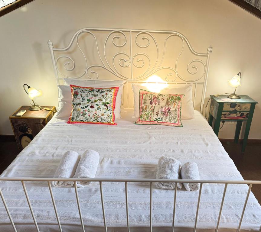 a bedroom with a white bed with two lamps at Happy Place in Rethymno