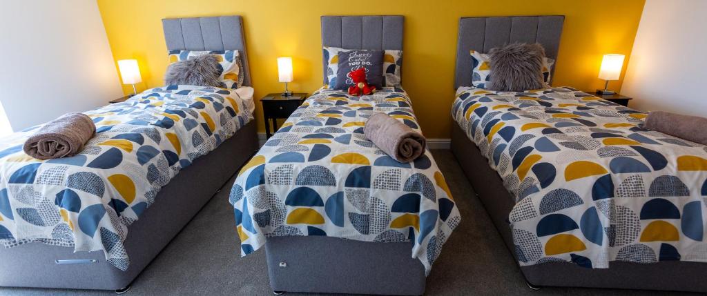 2 Einzelbetten in einem Schlafzimmer mit 2 Lampen in der Unterkunft Cosy Dragons, Sherlock Holmes in Abergavenny