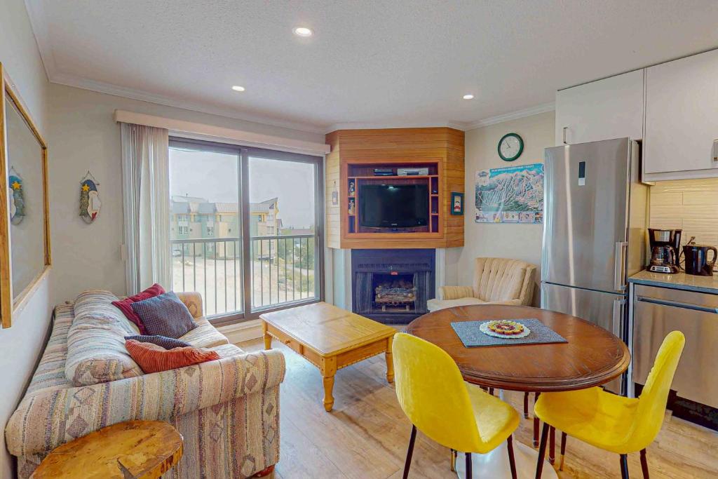 a living room with a couch and a table at Snow Ghost Inn 326 in Big White