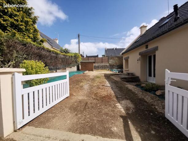 una cerca blanca junto a una casa y una entrada en Maison indépendante bord de mer, en Moëlan-sur-Mer