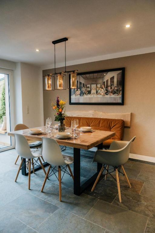 a dining room with a table and chairs at Ferienhaus Maarwinkel in Gillenfeld
