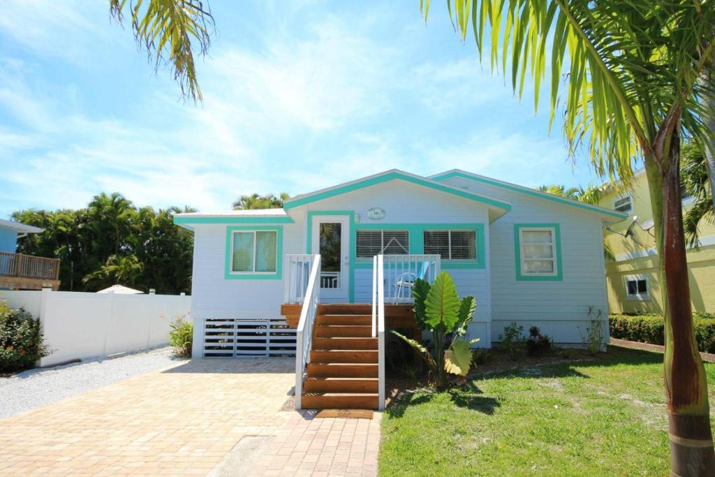 una casa azul con una palmera delante de ella en 231 Pearl Street, short walk to the beach, en Fort Myers Beach