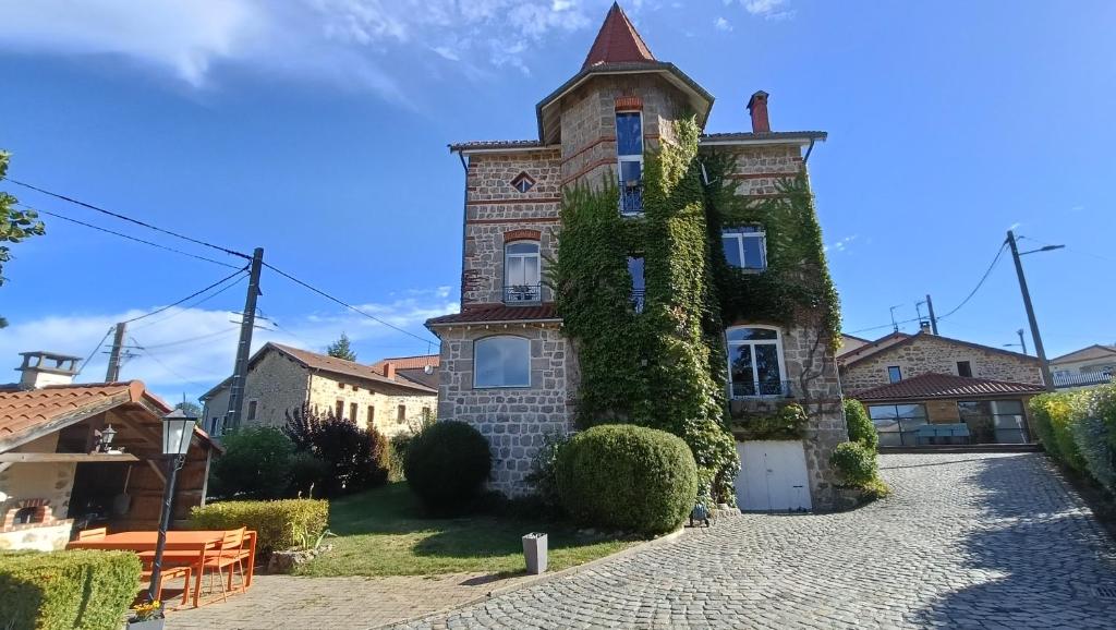 an old house with ivy on the side of it at Pierres et souvenirs in Usson-en-Forez