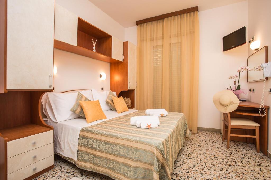 a hotel room with a bed and a desk at Hotel Oregon in Rimini