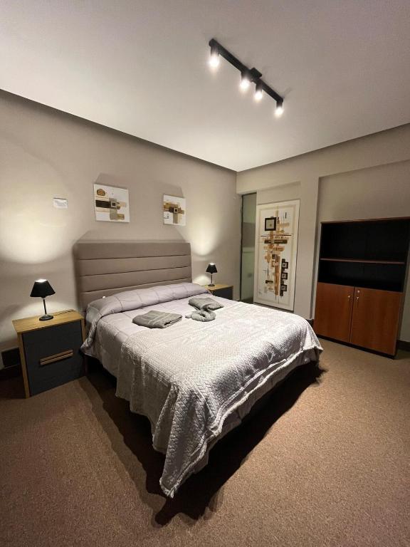 a bedroom with a large bed and two night stands at Lomar suite 2 - Depto céntrico Villa María in Villa María