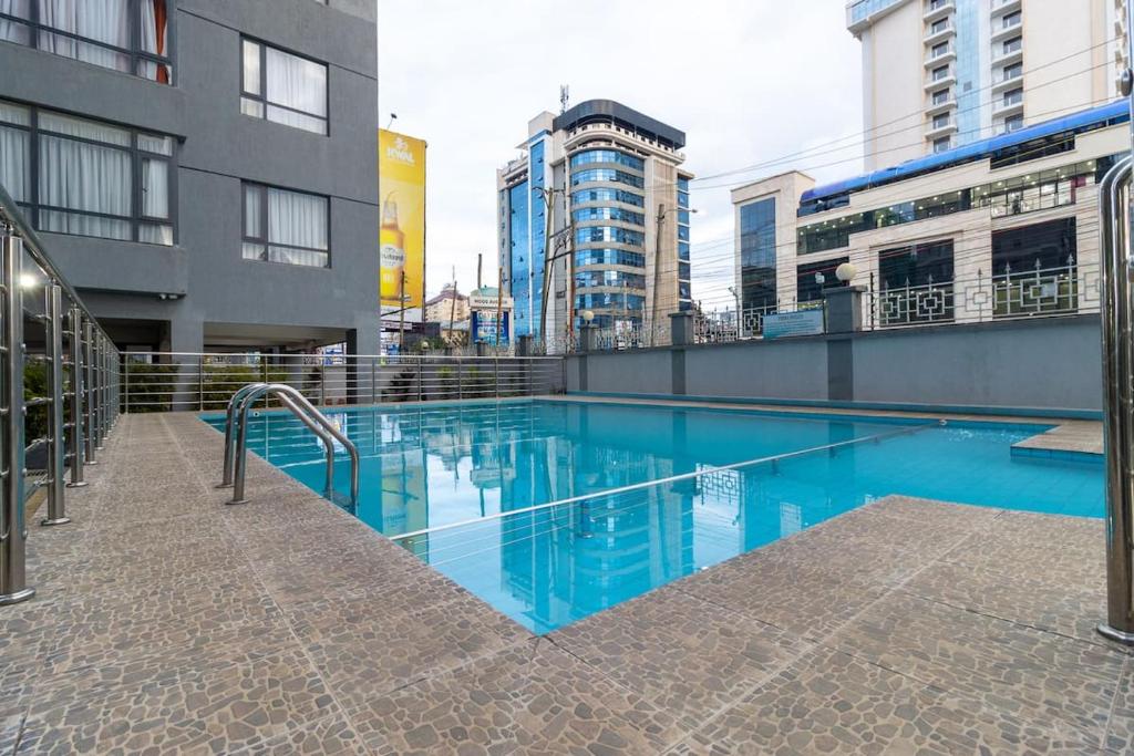 a swimming pool in a city with tall buildings at Orchid Residency, Westlands in Nairobi